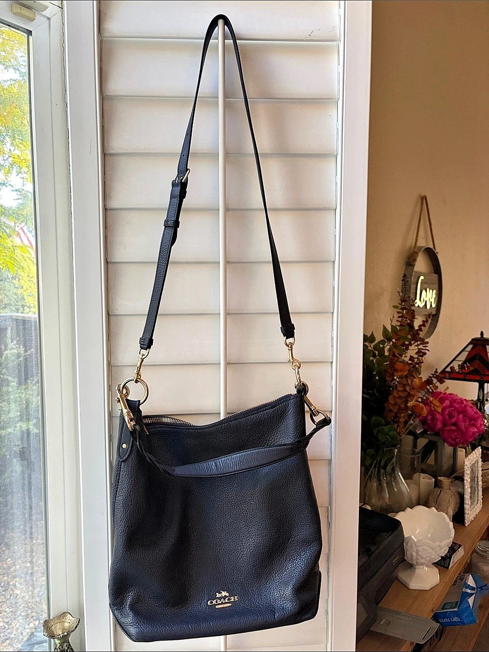 Coach Abby pebbled leather navy shoulder bag with two straps and gold hardware.